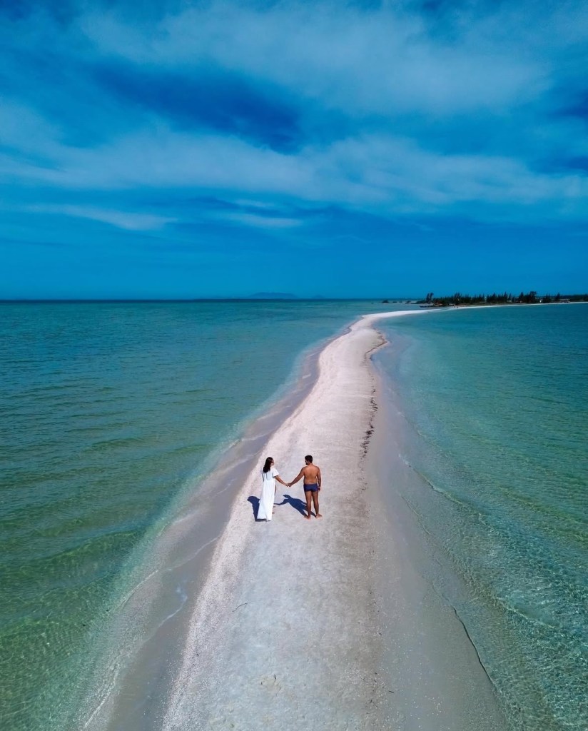 Casal caminhando no Caminho de Moisés em Arraial do Cabo, cenário paradisíaco