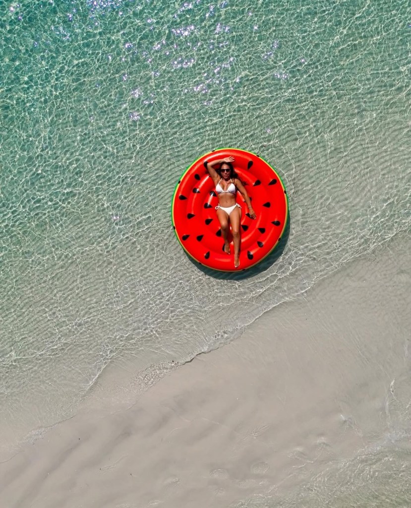 Foto aérea de pessoa relaxando em bóia no mar cristalino de Búzios