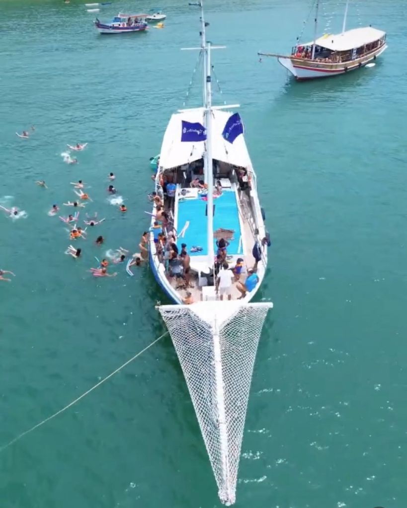 Turistas praticando snorkel em águas cristalinas durante passeio de escuna em Búzios