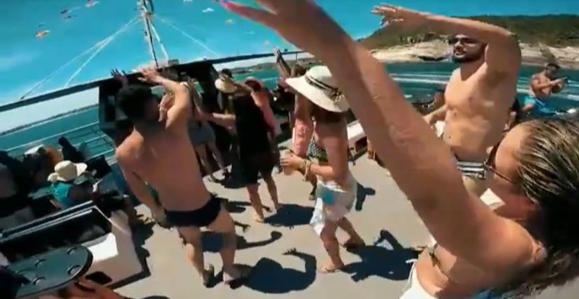Pessoas se divertindo e dançando no passeio de catamarã