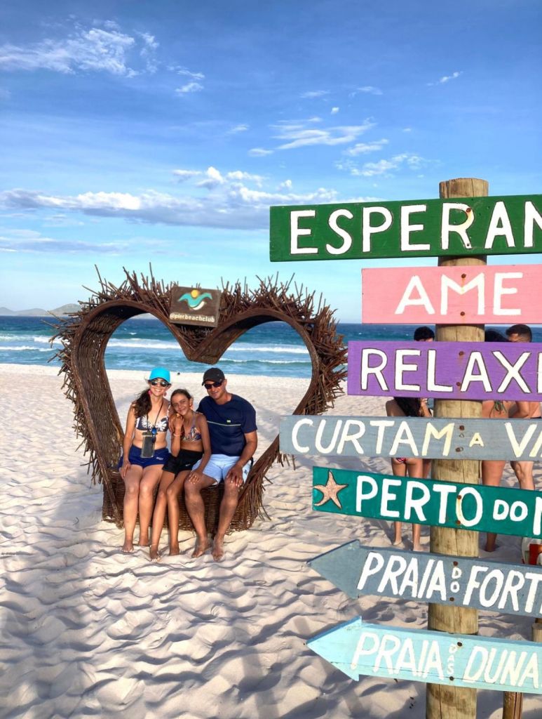 Grupo de amigos na moldura de coração em ponto turístico de Cabo Frio