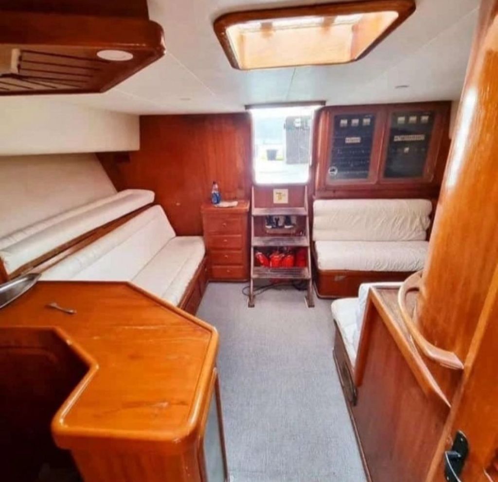 Cabine com sofá em L e mesa de jantar a bordo da lancha