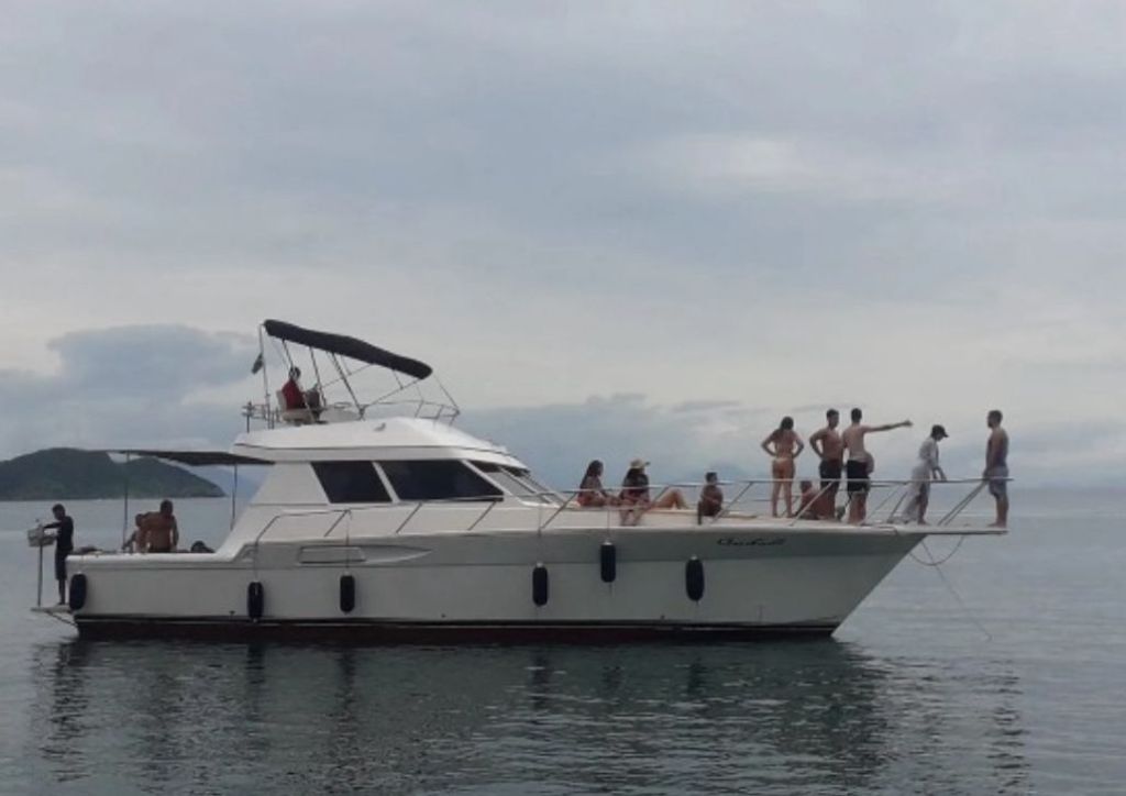 Lancha 45 pés com grupo de pessoas embarcando no píer em Búzios