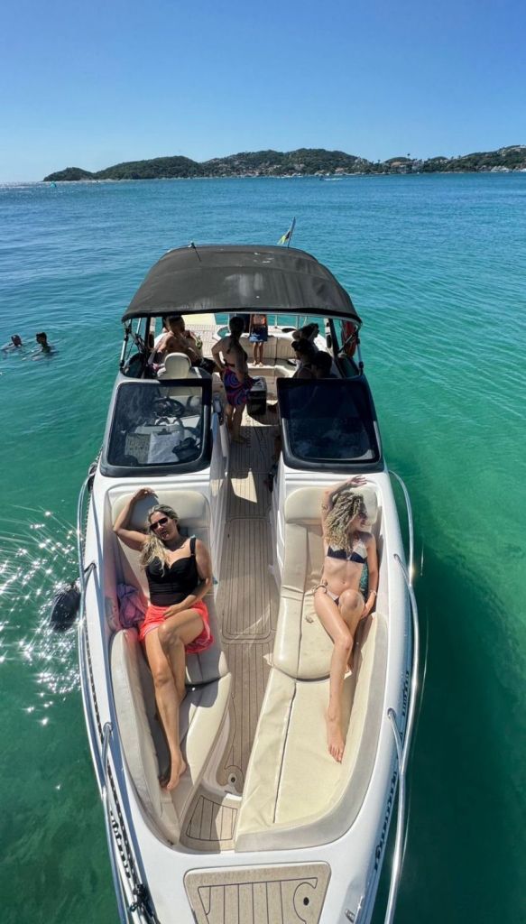 Lancha Coral 26 pés com passageiros relaxando em passeio em Búzios