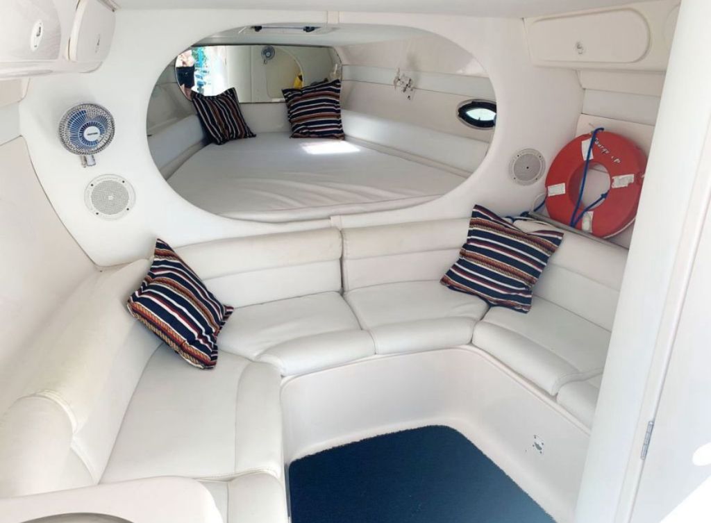 Interior da cabine da lancha 38 pés com sofá em U e almofadas