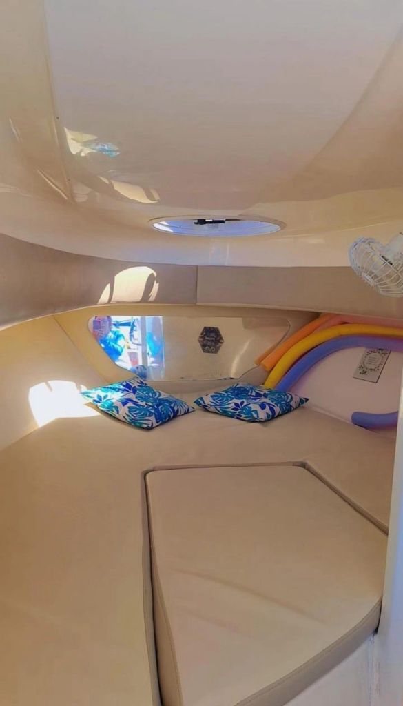 Cabine da lancha com iluminação azul e almofadas coloridas