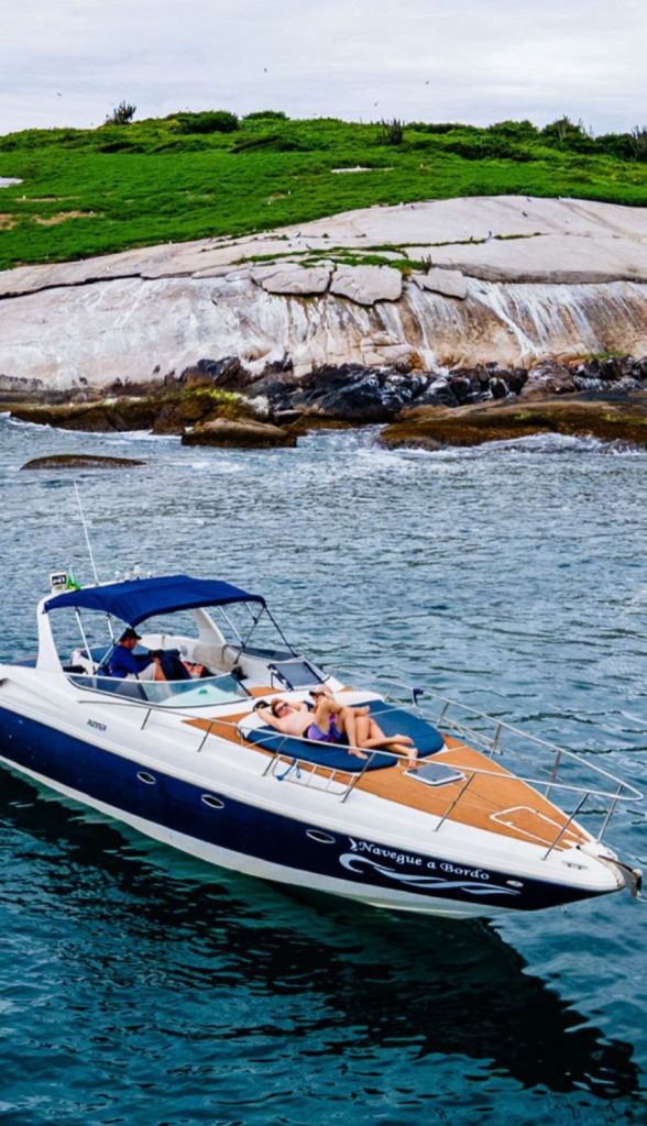 Lancha 38 pés navegando perto das pedras na costa de Búzios