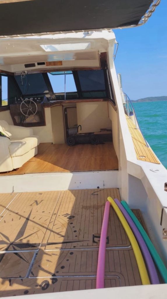 Interior da lancha com painel de comando e assentos acolchoados