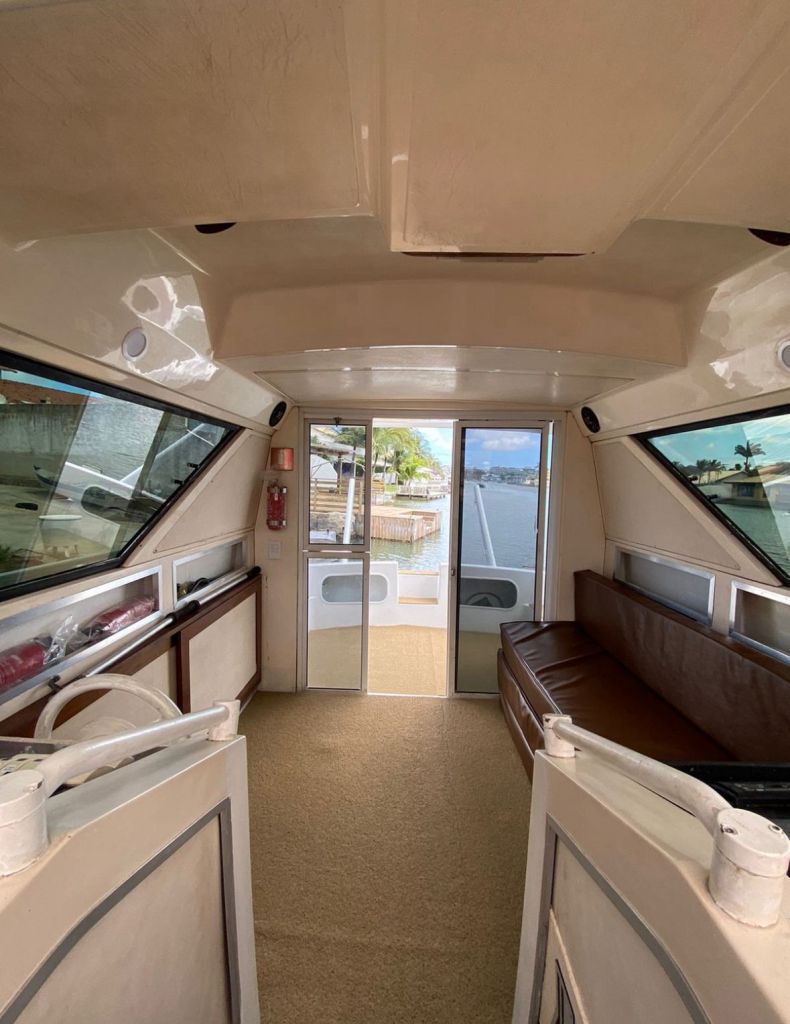 Interior da lancha com sala e entrada para cabine na Oceanic 32
