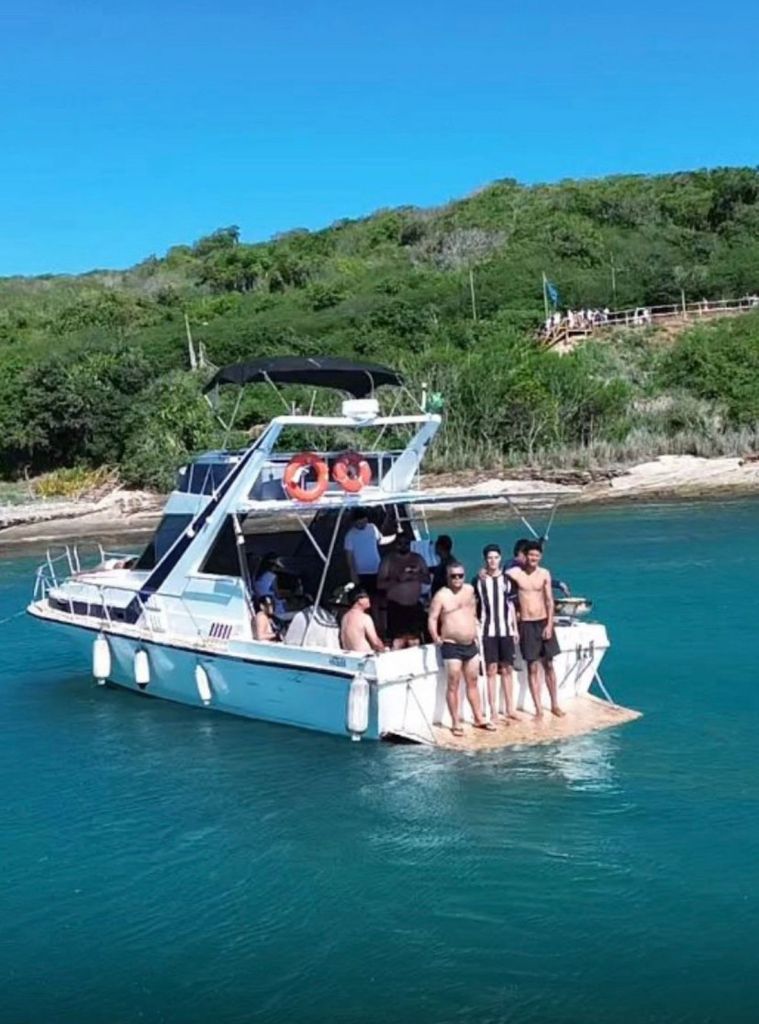 Turistas se divertindo ao lado da lancha Nhoa 38 pés com flutuadores em Búzios
