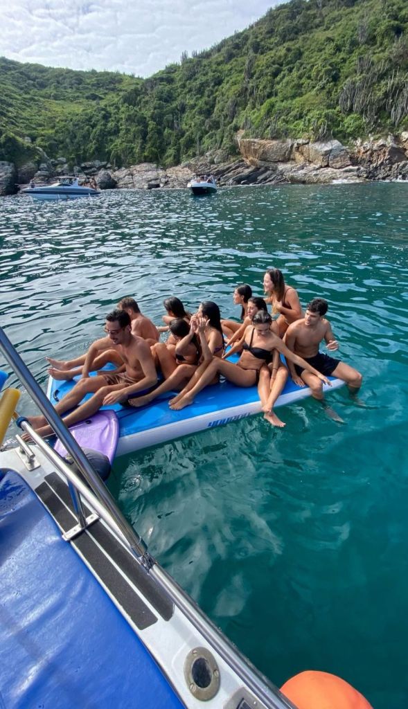 Grupo de amigos se divertindo na plataforma inflável durante o passeio