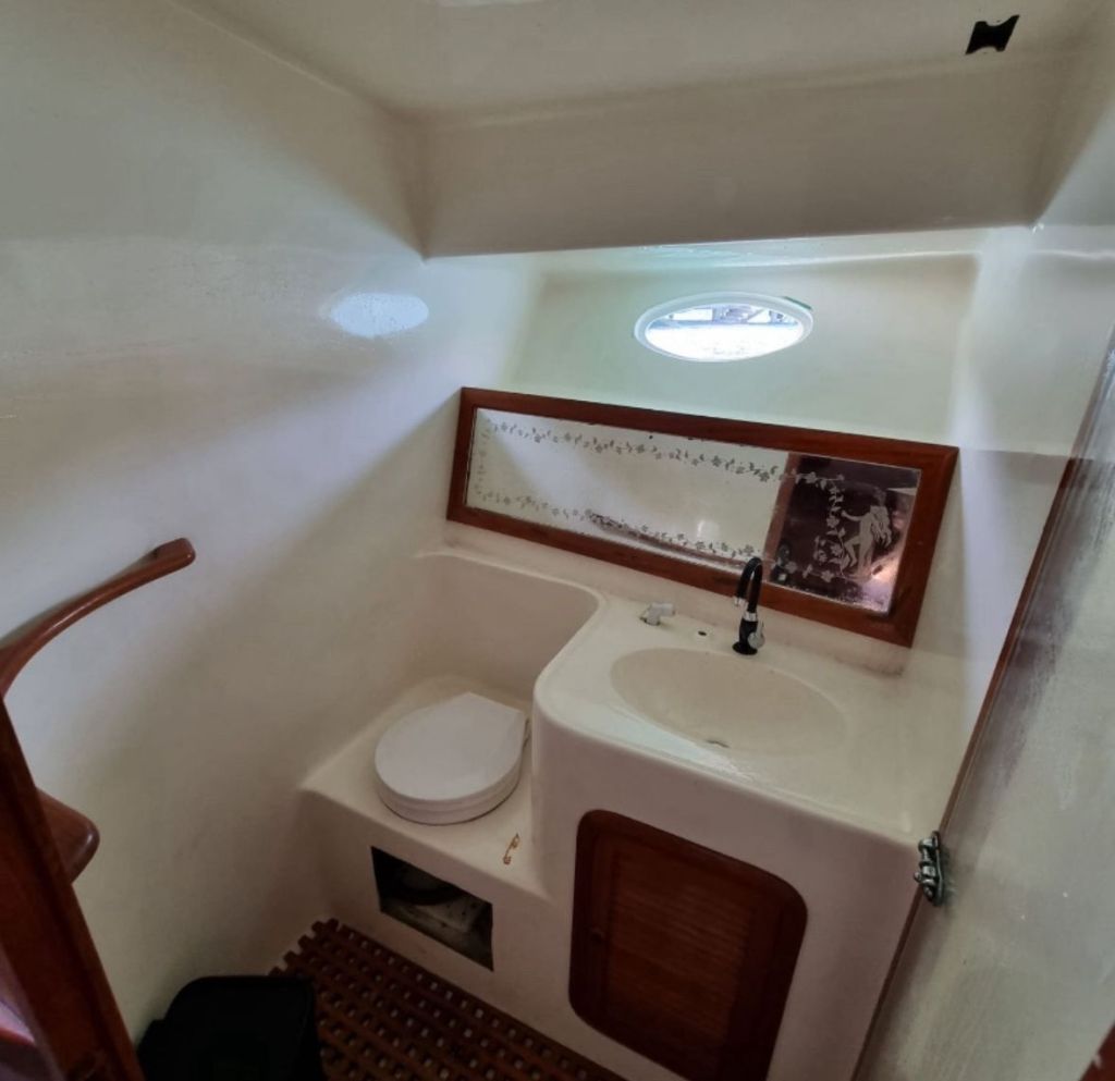 Banheiro completo da lancha com pia, espelho e vaso sanitário