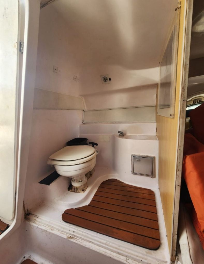 Banheiro da lancha com vaso sanitário e pia