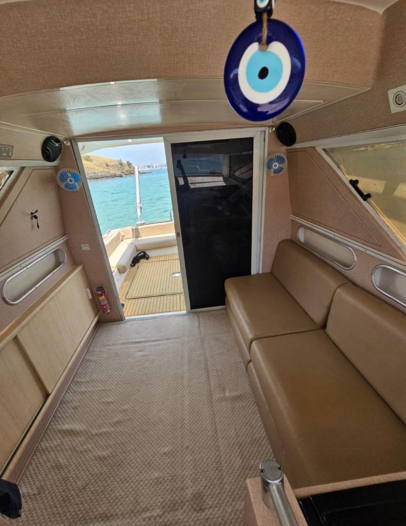 Área interna com sofá e entrada para o deck da lancha