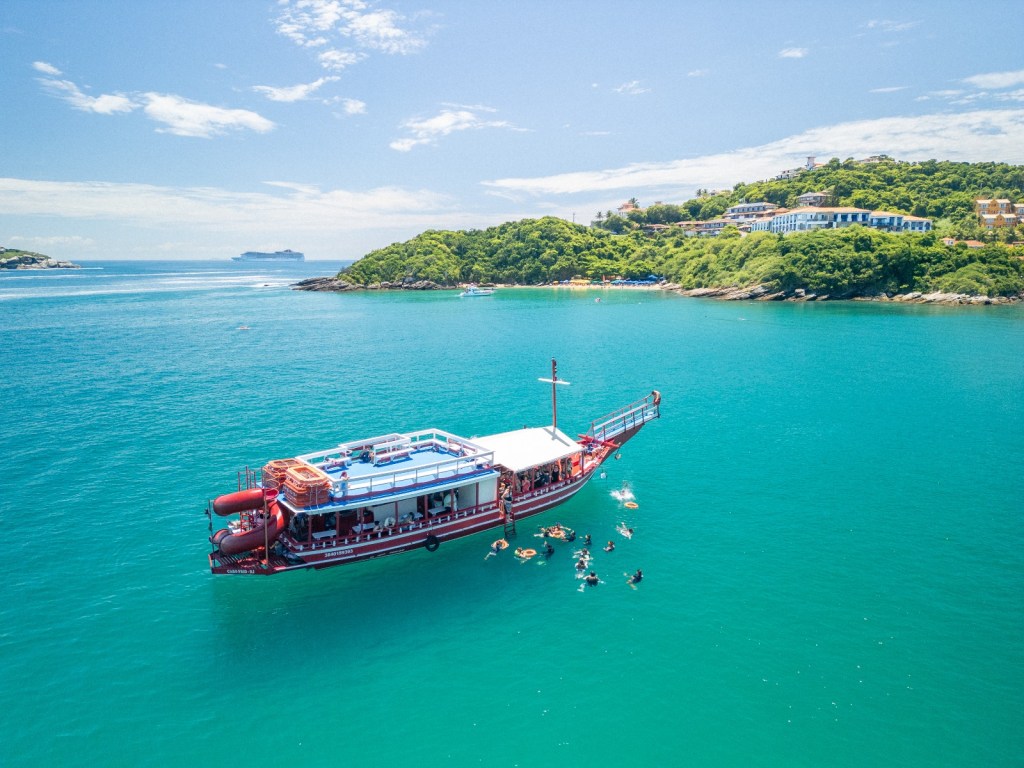 Escuna ancorada com turistas aproveitando o mar em Búzios