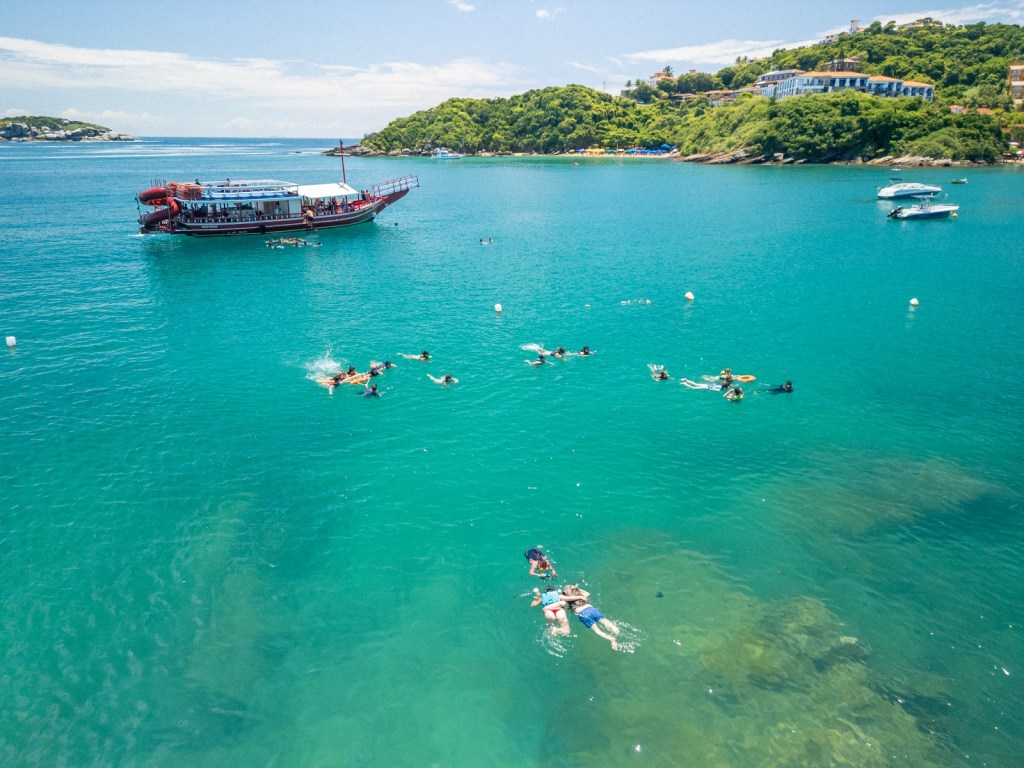 Passageiros mergulhando nas águas de Búzios durante o passeio